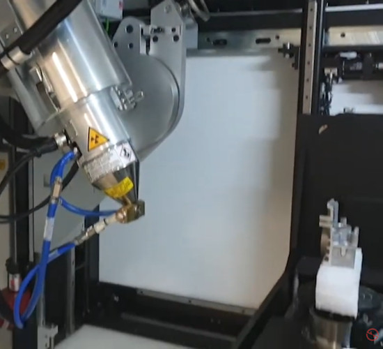 A 3d scanner shining structured blue light onto a metal gearbox