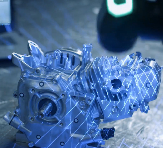 A 3d scanner shining structured blue light onto a metal gearbox